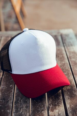 White, blue, red cap on wooden tableの写真素材