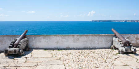 Two cannon in the fort of Sagres with the St Vincent cape at backgroundの写真素材