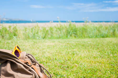 Bag and sunglasses on the grass in a sunny day