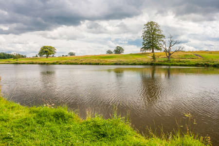 Beautiful river landscape with reflection in a cloudy dayの写真素材
