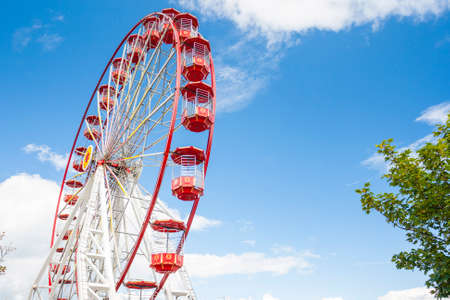Red Ferris Wheel against blue sky at amusement parkのeditorial素材