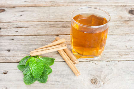 Close-up of a cup of tea with cinnamon and peppermintの写真素材
