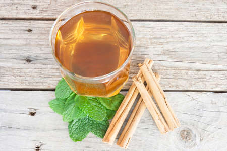 Close-up of a cup of tea with cinnamon and peppermintの写真素材