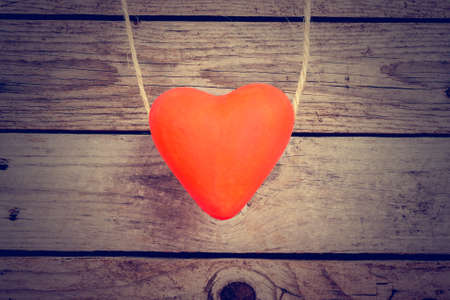Red hearts hanging on a rope over wooden backgroundの写真素材