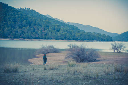 Woman walking around a lake with vintage postproductionの写真素材