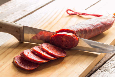 Close up of sliced iberian chorizo with knifeの写真素材