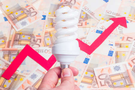 Growth of electricity price concept. Bulb with arrow pointing up over fifty euro notes backgroundの写真素材