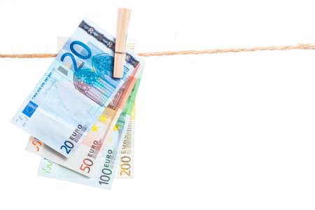 Euro banknotes hanging with peg from a rope isolated on white backgroundの写真素材