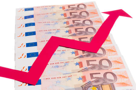 Concept of increase of euro value with red arrow growing over notes row isolated on white backgroundの写真素材
