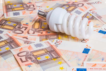 Price of electricity concept. Bulb over fifty euro notesの写真素材