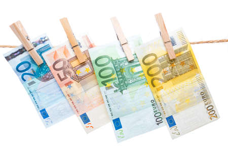 Euro banknotes hanging with peg from a rope isolated on white backgroundの写真素材