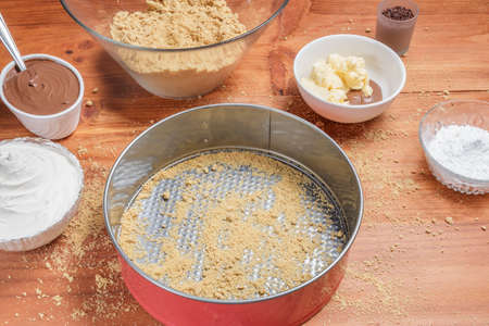 Ingredients for making a chocolate cheesecake on wooden table