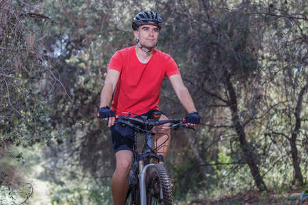 Young adult man riding a bike in natureの写真素材