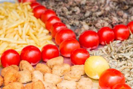 Different kind of food separated by a tomatoes lineの写真素材