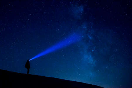 Woman with lantern at night with stars and milky wayの写真素材