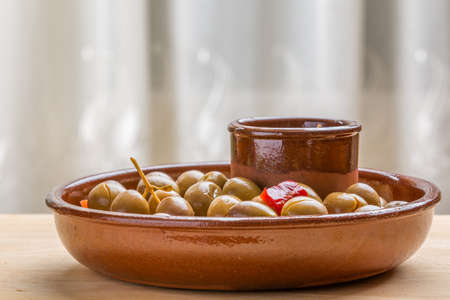 Close-up of marinated green olives snack in ceramic plateの写真素材