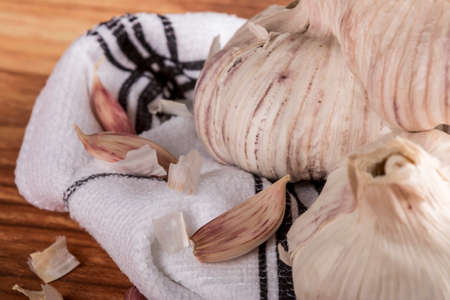 From above unpeeled garlic bulb and cloves on wooden table. Horizontal studio shot
