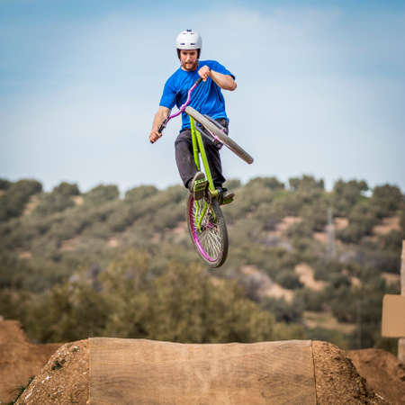 Sportsman performing trick and flying on a bike in nature on dirtjump circuitの写真素材