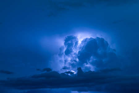 View of big thundercloud of storm flowing in dark blue evening skyの写真素材