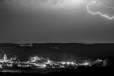 View of magnificent thunderstorm over small town at nightの写真素材
