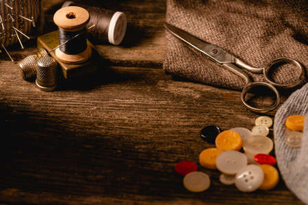 Close-up view of sewing spools with white and black thread and needle, thimbles and variety of...