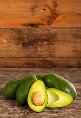 Closeup halves of fresh ripe avocado with big seed placed on plaster surfaceの写真素材