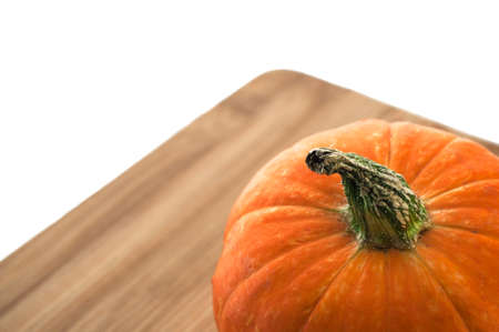 Orange pumpkin on a wooden board isolated on white backgroundの写真素材