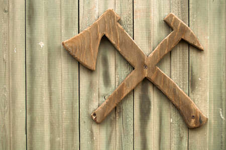 Wooden signboard of carpenter workshop: ax and hammerの写真素材