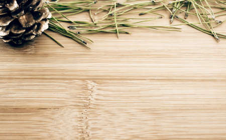 Christmas theme background with pine needles, pinecone and wooden copy spaceの写真素材
