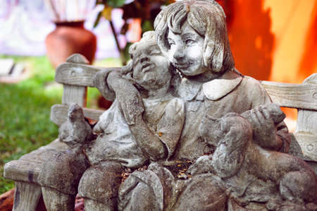 Art object on street: sculpture of two children with a dog on a benchの写真素材