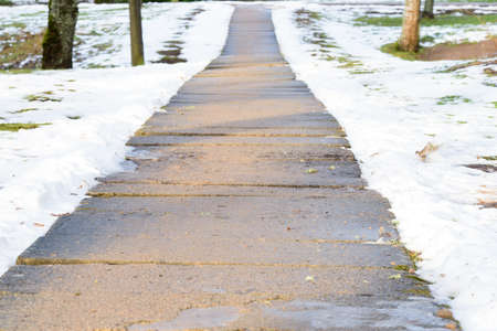 a beautiful cleared path in the park in the middle of winterの写真素材