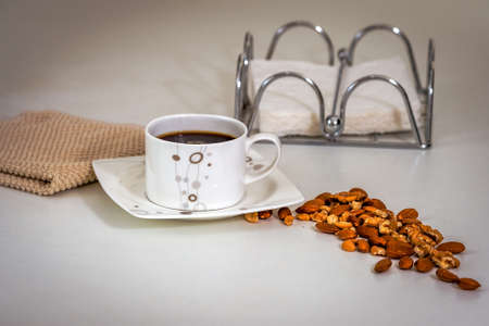 Black coffee and nuts in the breakfast, placed on the table near white napkins.の写真素材
