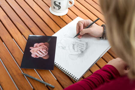 Blond woman artist drawing in the process