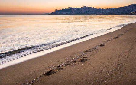 Foot prints in the sand of the beach of Kavala in Greece during the sunset