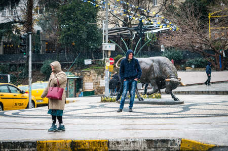 Istanbul, Turkey - January 18, 2016: People are walking next to the bull statue at the Kadikoy square. Often it is used as a meeting point in the Kadikoy, Istanbulのeditorial素材