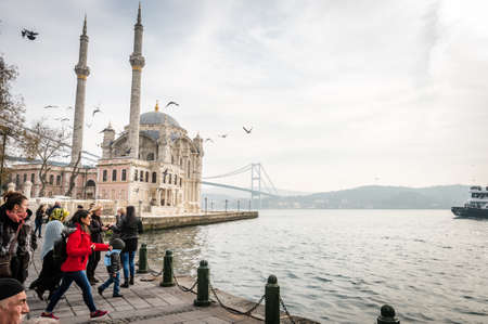 Istanbul, Turkey - January 31, 2016: People spending weekend in Ortakoy near beautiful mosque and...
