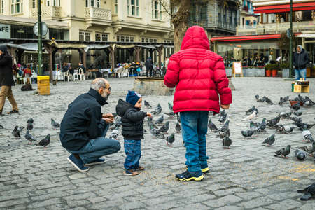 Istanbul, Turkey - January 31, 2016: People spending time on weekend and children are feeding pigeons near Bosphorus in Istanbul.のeditorial素材