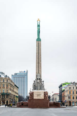 Riga, Latvia - February 20, 2016: People are walking near the Freedom Monument in Riga, Latviaのeditorial素材