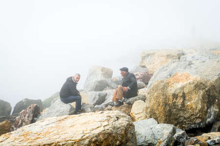 Istanbul, Turkey - February 29, 2016: Turkish men are sitting on the coast of Kadikoy in a very foggy dayのeditorial素材