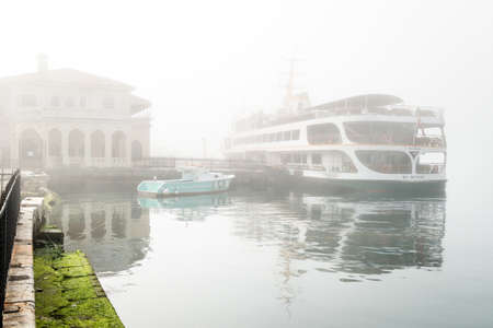 Istanbul, Turkey - February 29, 2016: Kadkoy port in a smog. Ferry boats on Bosphorus are not...