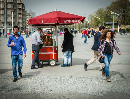 Istanbul, Turkey - April 08, 2016: People are walking at Taksim square  where street seller is selling Turkish bagels in Istanbul, Turkeyのeditorial素材