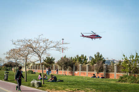 Istanbul, Turkey - April 18, 2016: Young people are sitting at seaside in Kadikoy while helicopter is passing over in Istanbul, Turkeyのeditorial素材