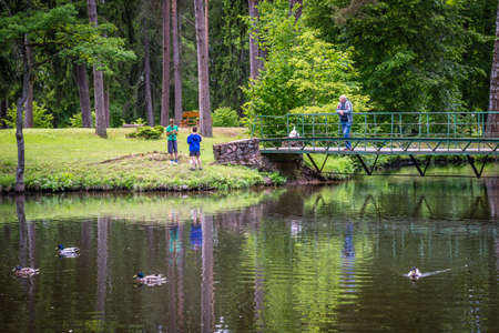 Gulbene, Latvia - Jun 13, 2016: People are resting and children are fishing in the pond of Sparites park in Gulbene, Latviaのeditorial素材