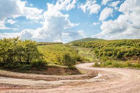 Mountain landscape with cart road in forground at cloudy dayの写真素材