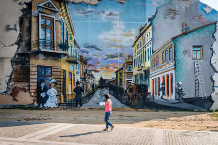 Craiova, Romania - September 16, 2016: Woman is walking near paÃï¿½ted wall on Fratii Buzesti street in Craiova, Romaniaのeditorial素材