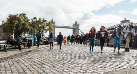 London, United Kingdom - October 20, 2016: People are walking on the coast of river Thames near the Tower of London on the background of Tower bridge in London, Englandのeditorial素材