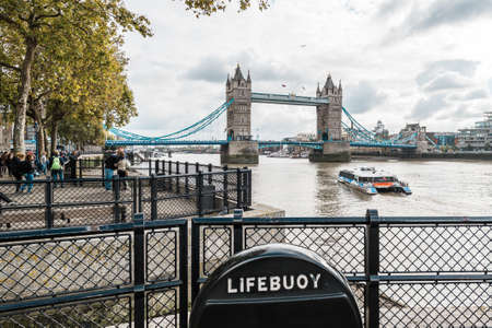 London, United Kingdom - October 20, 2016: People are walking on the coast of river Thames near the Tower of London on the background of Tower bridge in London, Englandのeditorial素材
