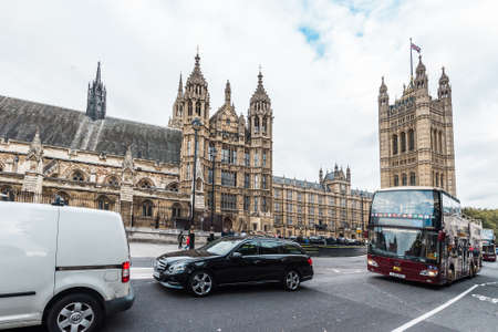 London, United Kingdom - October 20, 2016: Cars are passing by the Palace of Westminster which is the meeting place of the House of Commons and the House of Lords, the two houses of the Parliament of the United Kingdomのeditorial素材