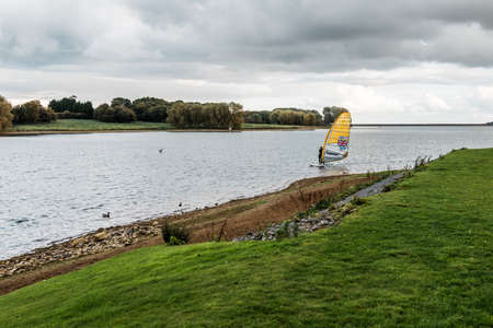 Rutland Water Park, England - October 22, 2016: Person is sailing on Rutland water, England, United Kingdomのeditorial素材
