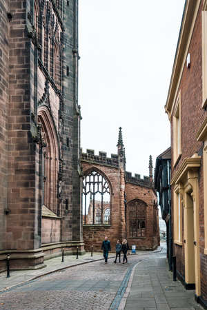 Coventry, England - October 23, 2016: people are walking on the street and passing by the runied Cathedral Church of St Michaelのeditorial素材